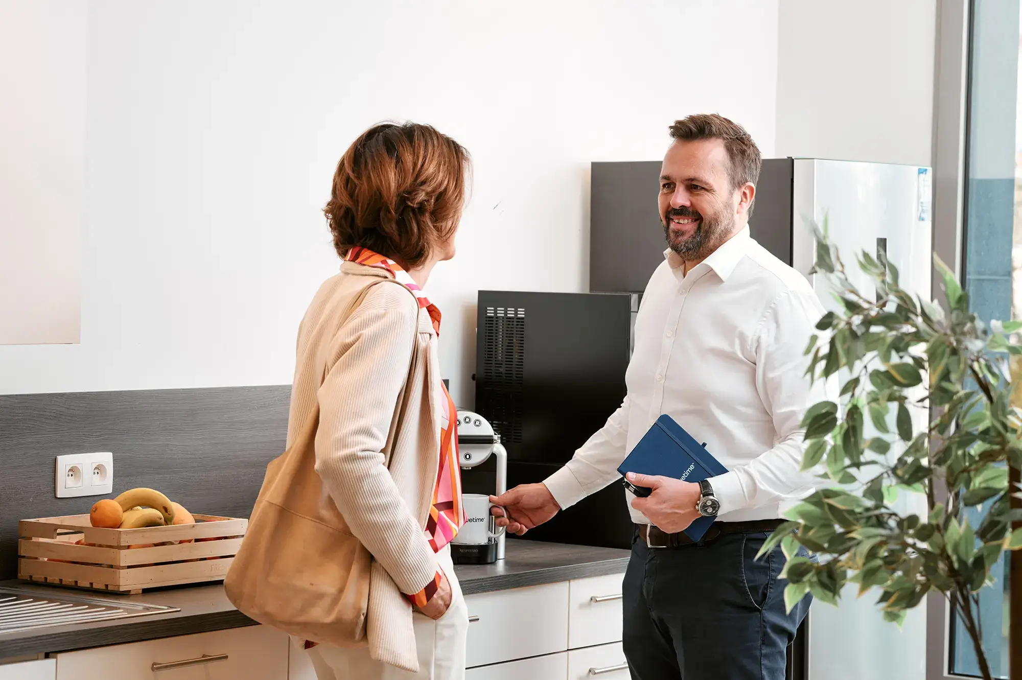 Twee collega's praten in de keuken van het bedrijf Bluetime.