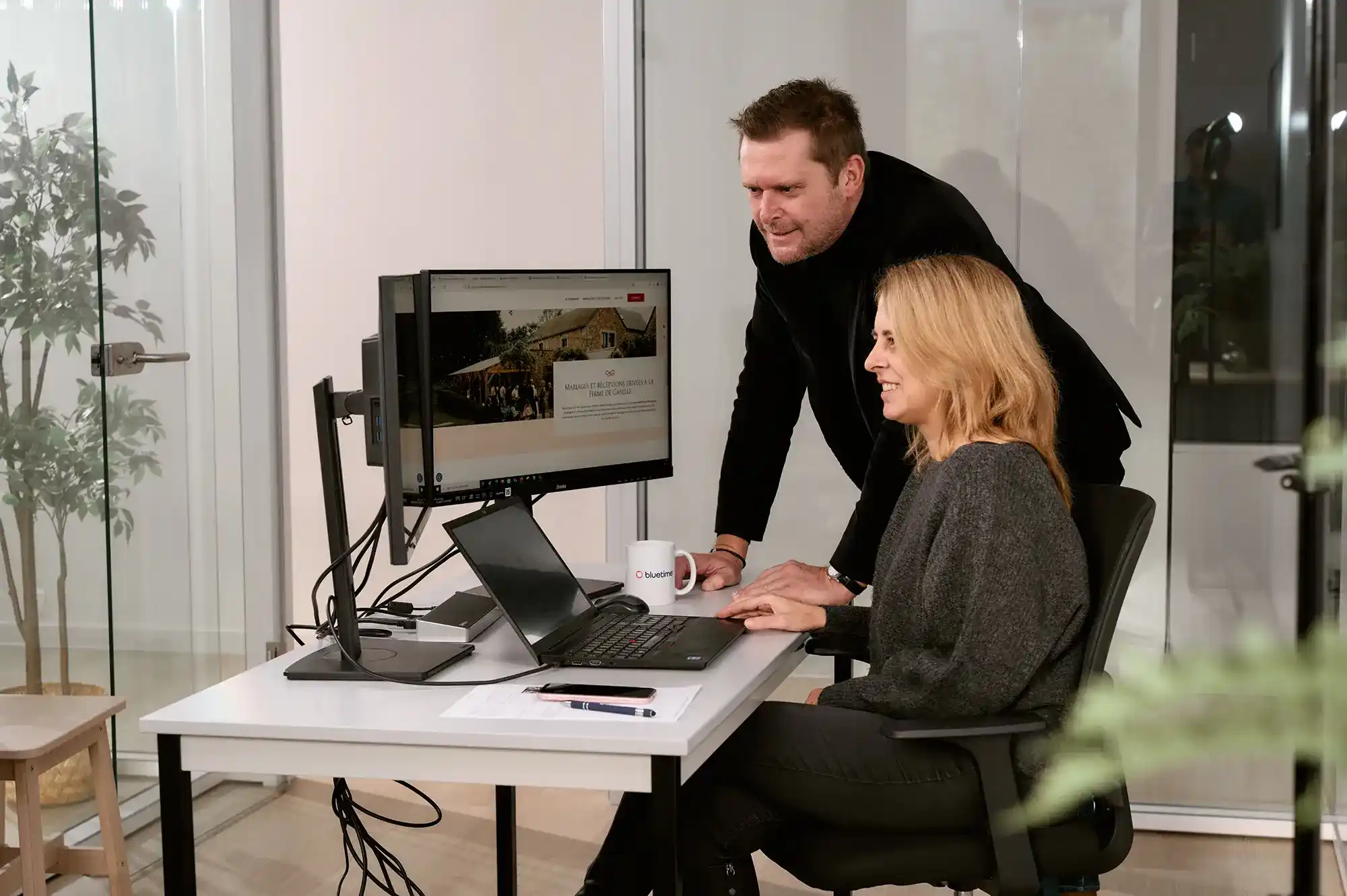 Une project manager et un commercial travaillent sur le site d’un client sur ordinateur