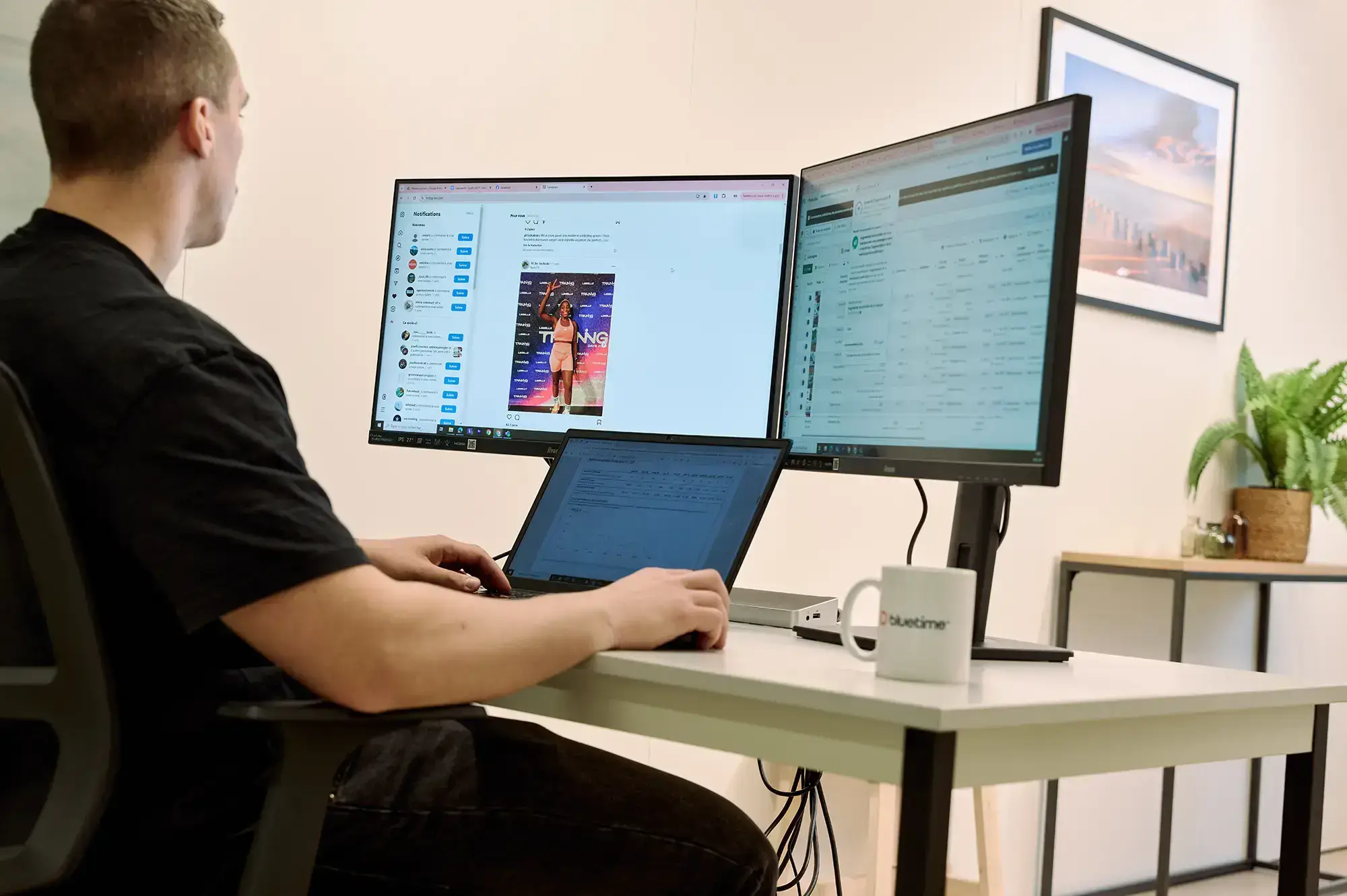 A web designer develops a website on his three computer screens