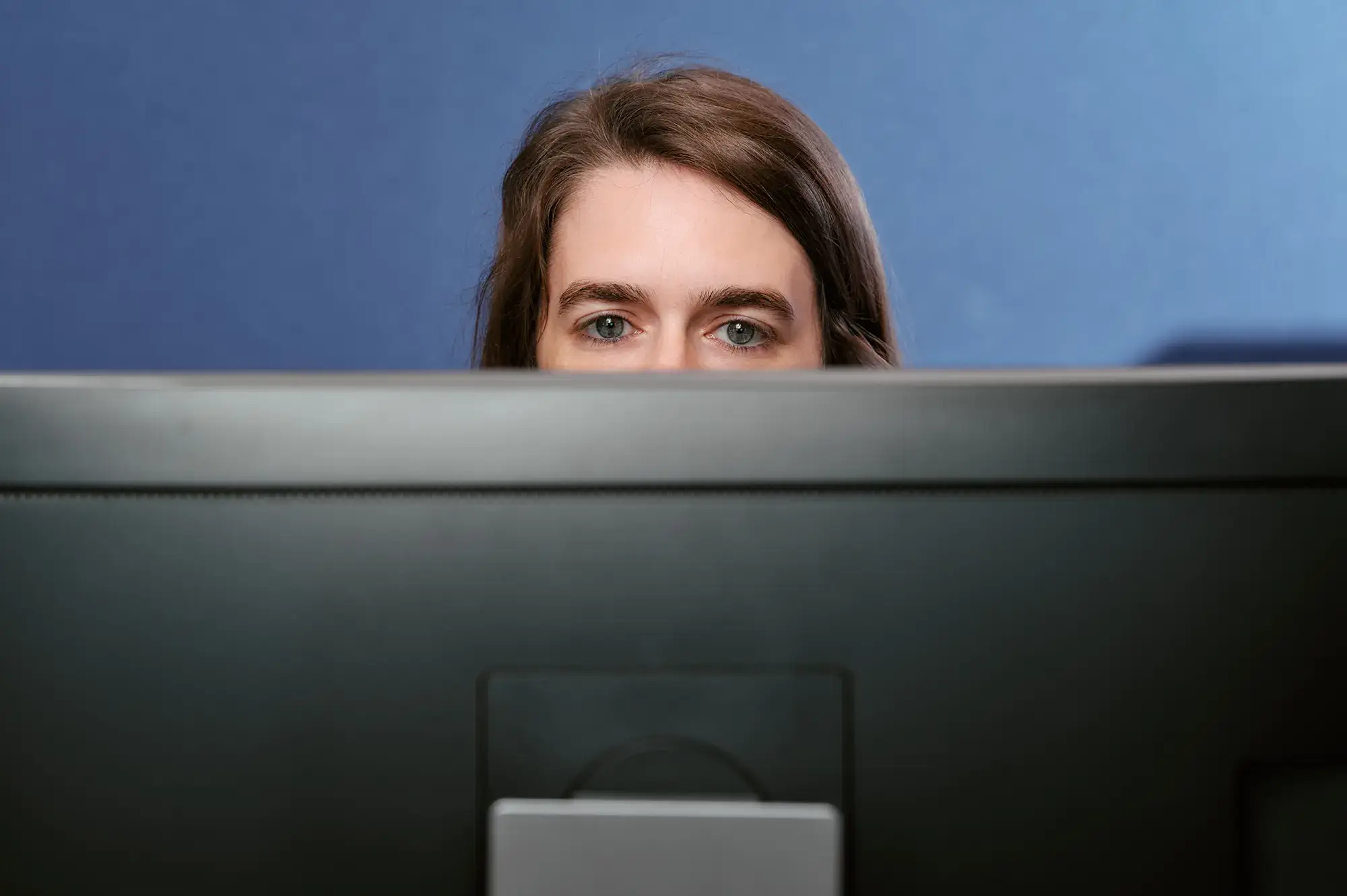 Zoom sur le haut du visage d’une copywriter derrière son ordinateur