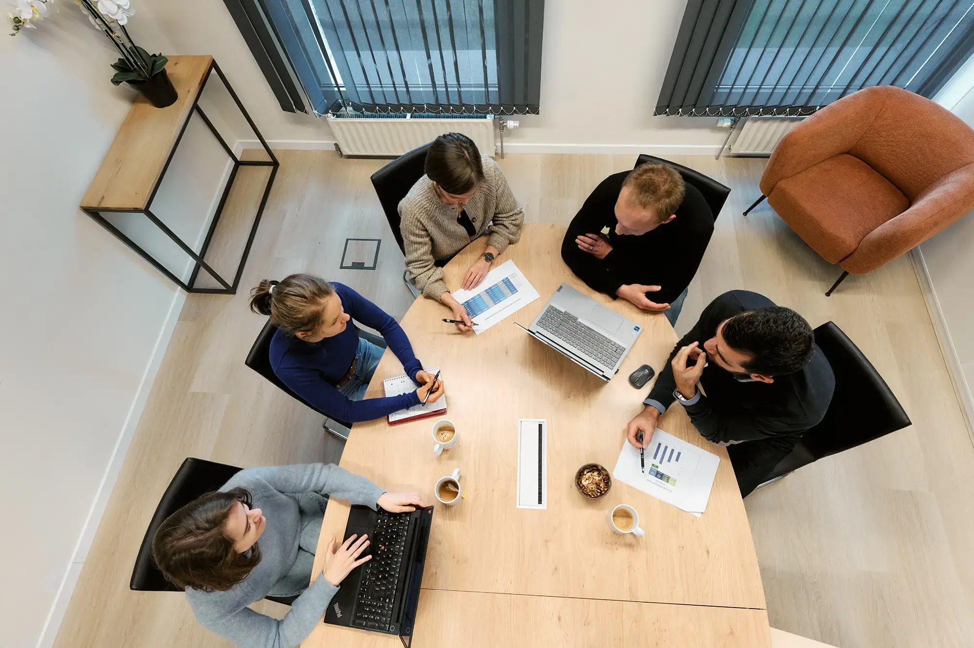Réunion entre cinq experts en stratégie digitale avec une vue en plongée