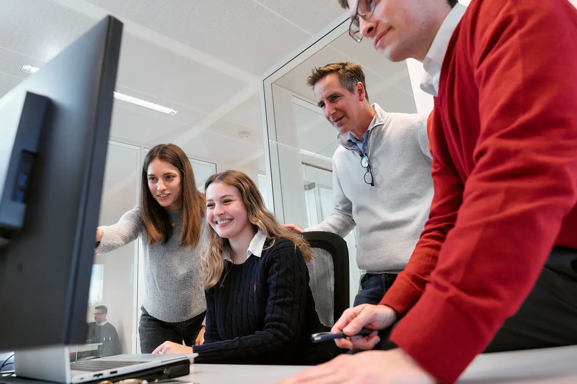 Four digital strategy experts collaborating on a computer